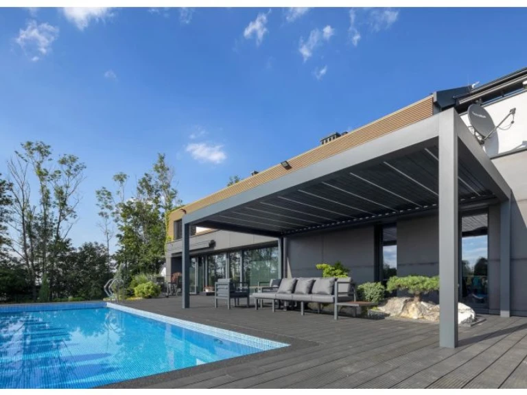 Moderná sivá bioklimatická pergola SUNBEAM 1400 na terase pri bazéne s exteriérovým sedením