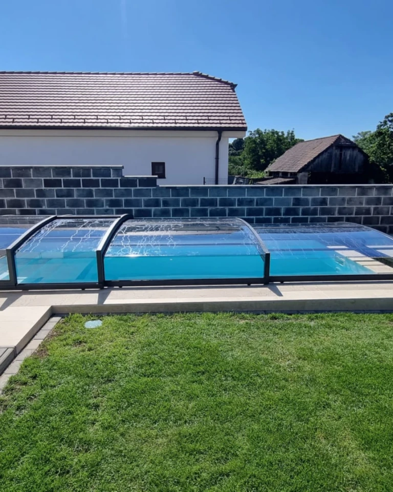 Moderné nízke bazénové prekrytie s čírymi stenami pri rodinnom dome