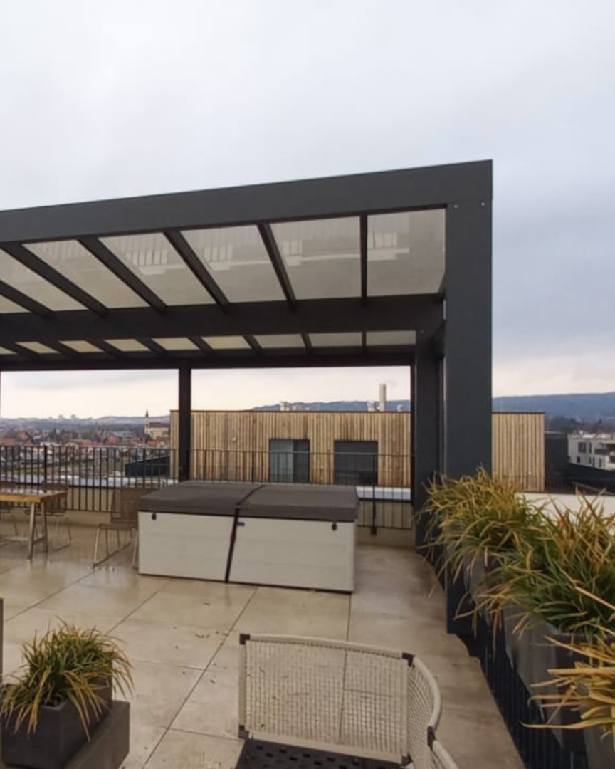 Moderná hliníková pergola na strešnej terase s výhľadom na mesto a vírivkou