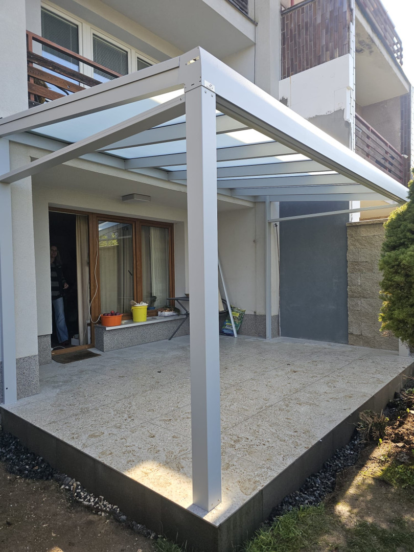 Moderná hliníková pergola so sklenenou strechou na terase rodinného domu