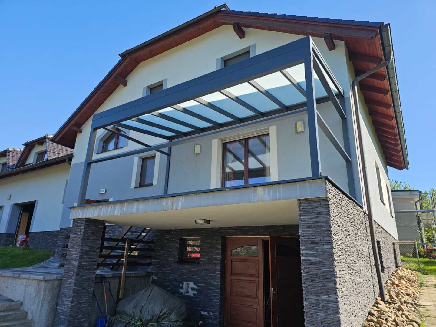 Moderná hliníková pergola so sklenenou strechou namontovaná na balkóne rodinného domu