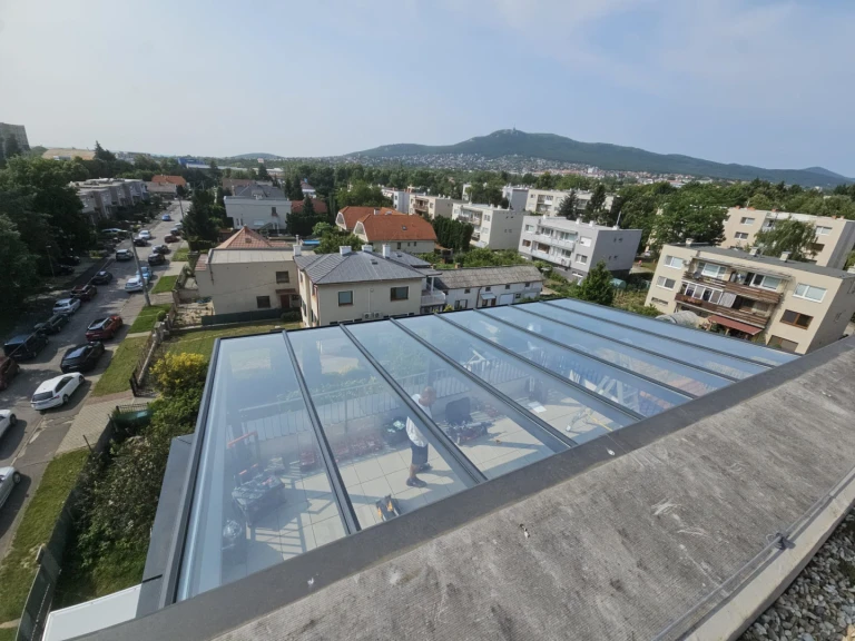 Pohľad zhora na presklenú hliníkovú pergolu na terase bytu v meste Nitra