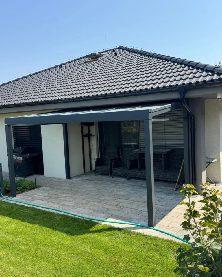 Moderná sivá hliníková pergola Robust na terase rodinného domu so sedením a záhradou