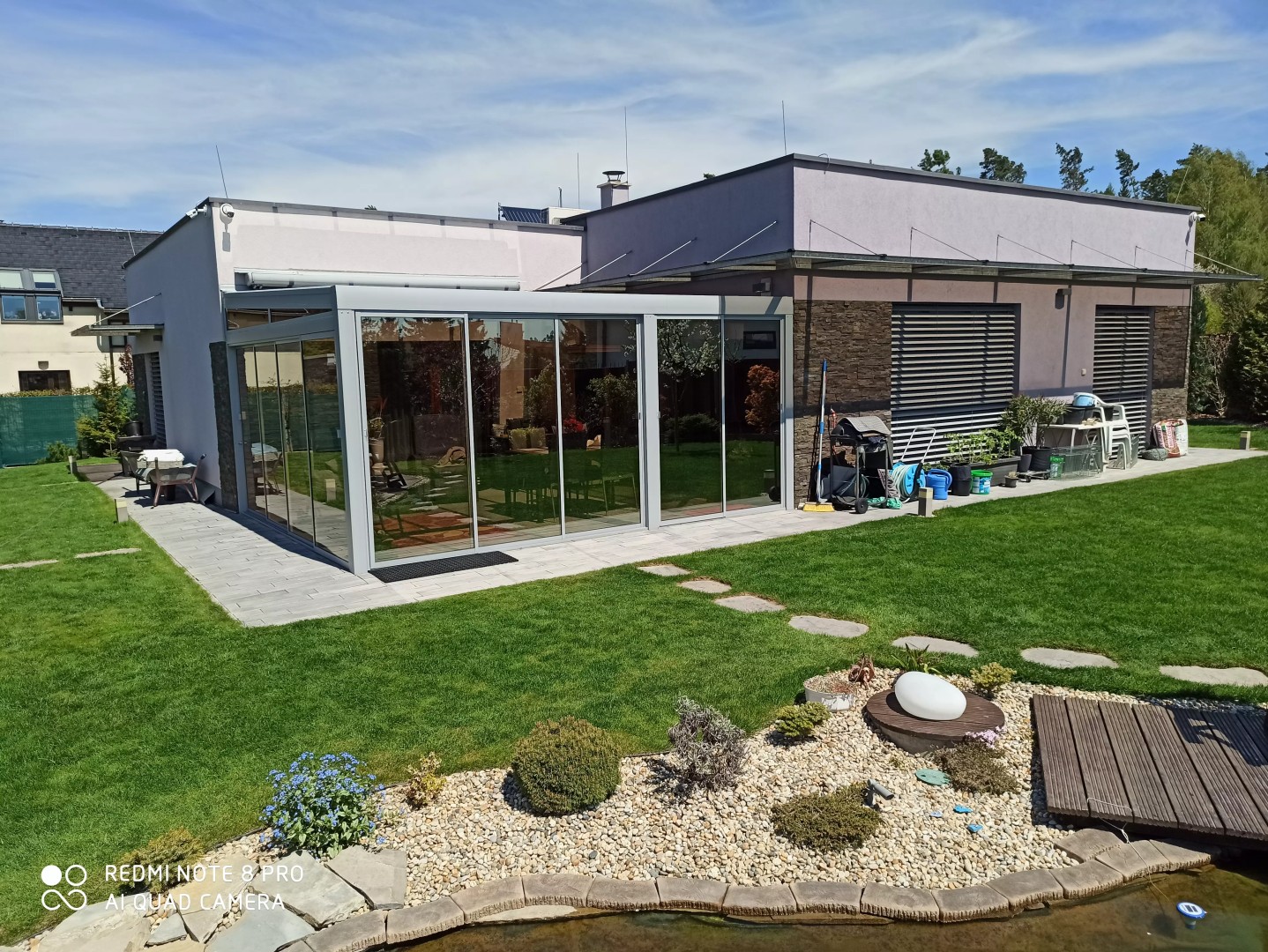 Moderná hliníková pergola so zasklením pri rodinnom dome v záhrade