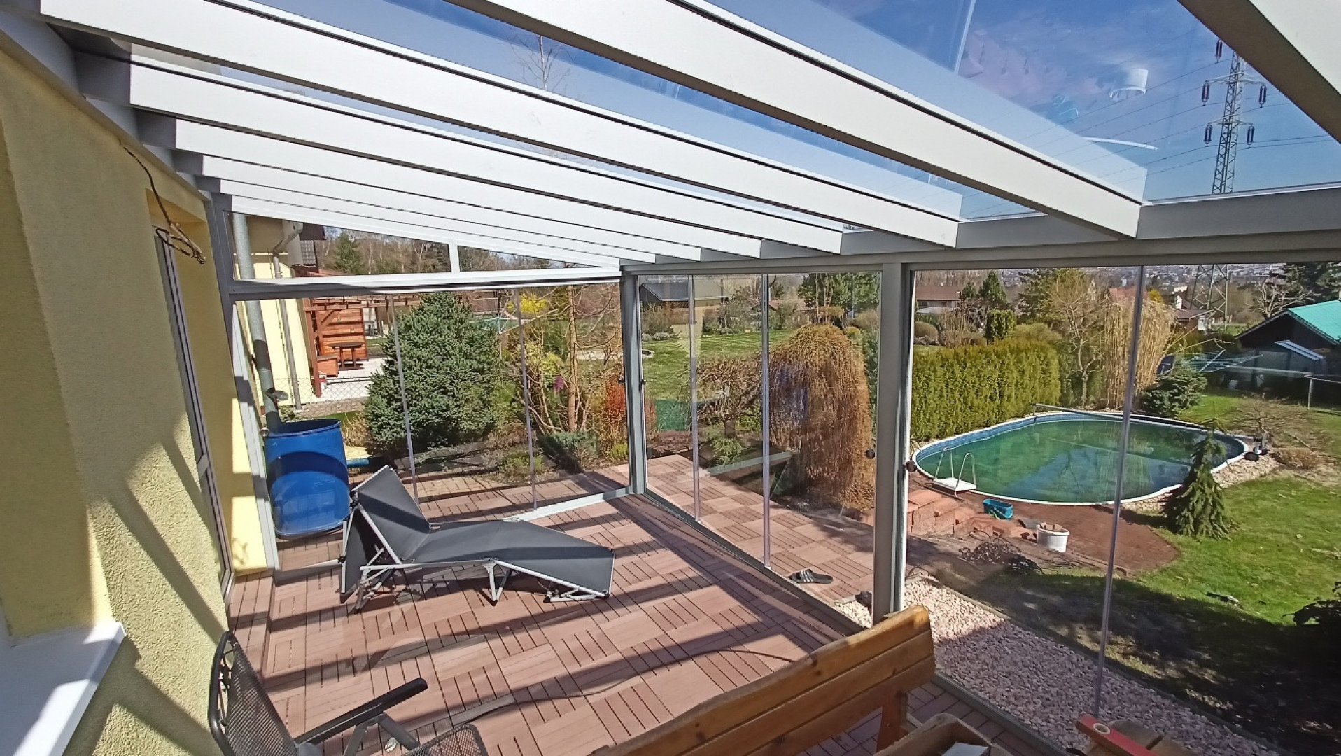 Moderná presklená hliníková pergola s terasou a výhľadom na záhradu s bazénom