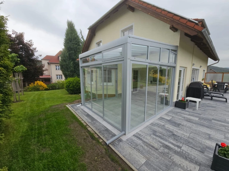 Moderná presklená zimná záhrada s hliníkovou konštrukciou pristavená k rodinnému domu